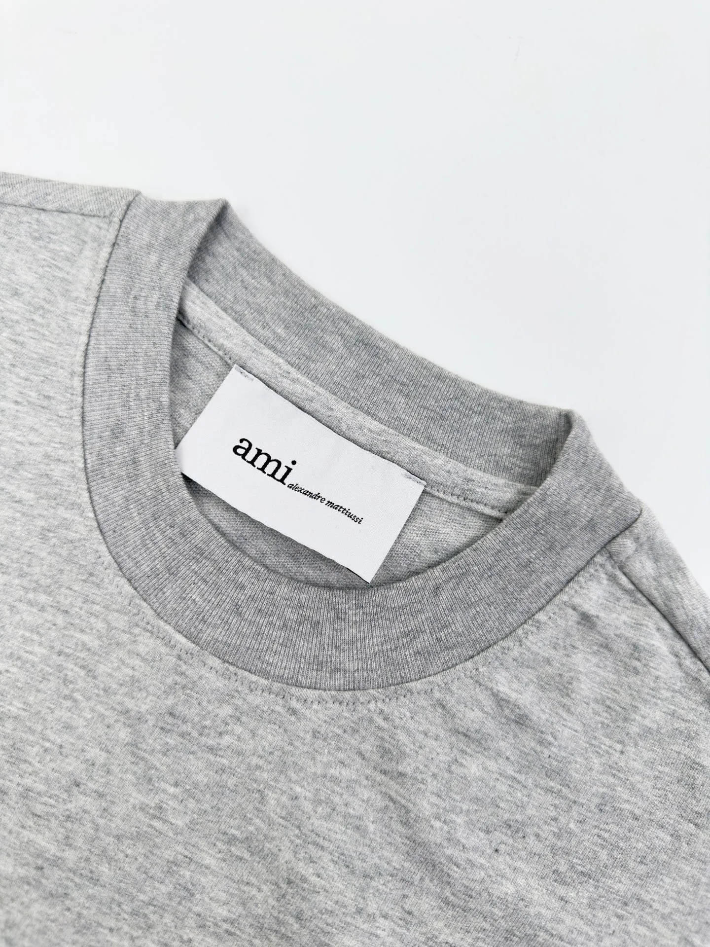 Ami Paris logo embroidered short sleeves. Custom-made high-count densely spun cotton. Soft and delicate, comfortable and skin-friendly. The hemp gray background is like mist on the body. The extremely restrained color tone demonstrates an effortless sense of luxury. The love logo on the chest is embellished with rough particles. The same color AMI embroidery on the back quietly echoes. French romance is hidden in the details. Low-key but highly recognizable. Use minimalist strokes to outline a luxurious and relaxing world. Process 1: Use imported machine embroidery technology. Use advanced computer control systems and precision mechanical components to realize Ami logo and letter embroidery operations with high precision and smooth and delicate lines. Process 2: The fabrics have been fermented and washed for better hand feel. Not easy to deform, not easy to shrink, not easy to fade, and maintain long-term beauty. Accessories: Customized 1:1 Ami trademark. Version: Loose version. Size: S M L XL. Style number: BB 820.